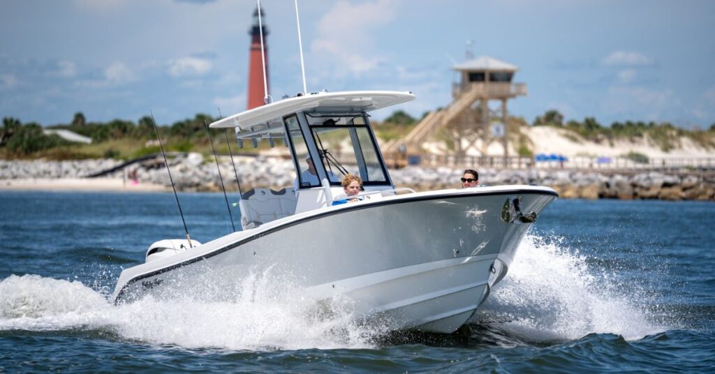 EdgeWater 250CC center console cutting through waves near lighthouse