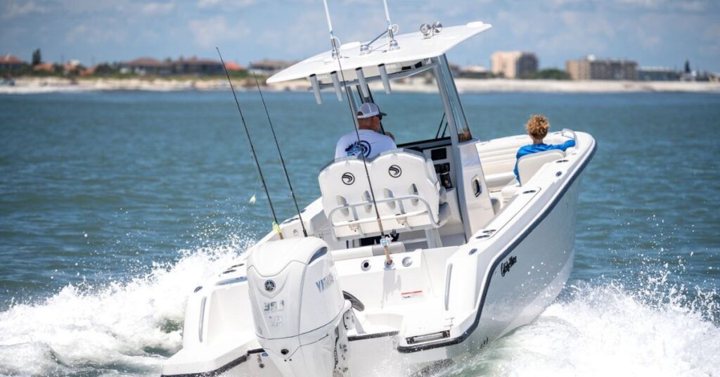 EdgeWater 250CC with Yamaha outboard, fishing rods and seating shown underway