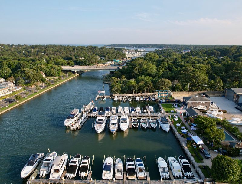 Aerial photo of Hampton Bays marina filled with yachts and boats with tree line in the distance