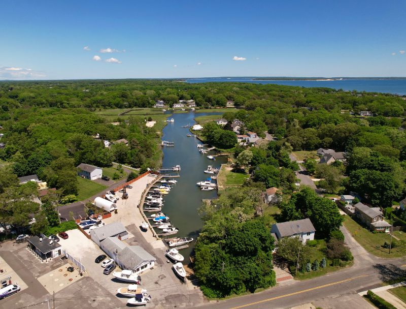 Drone view of Mattituck marina with slips, service yard, and nearby homes