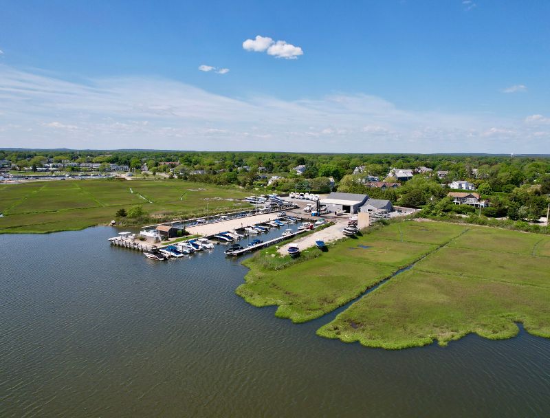 Wide aerial of Westhampton marina, slips, and surrounding marshland and neighborhood